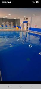 a swimming pool with blue water in a building at Life is Adventure in Great Clacton
