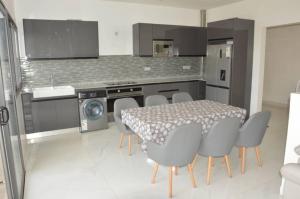 a kitchen with a table and chairs in a kitchen at Villa Keur Carla in Niangol