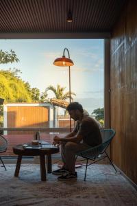 a man sitting in a chair next to a table at Tregua Bacalar in Bacalar +66 photos