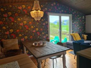 a living room with a table and a chandelier at Nordfjordcabins RED in Utvik +39 photos