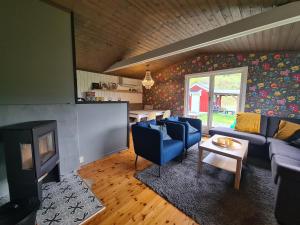 a living room with a couch and a tv at Nordfjordcabins RED in Utvik