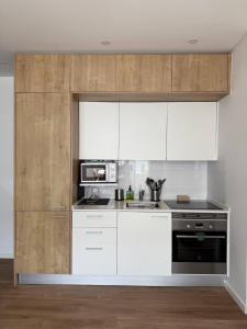 a kitchen with white appliances and wooden cabinets at Estoril by the Sea in Estoril