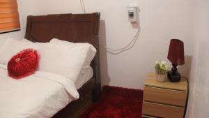 a bedroom with a bed with a red pillow on it at Phoenix Bliss - Amber in General Trias