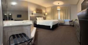 a hotel room with a bed and a bath tub at Companion Hotel Motel in Hearst