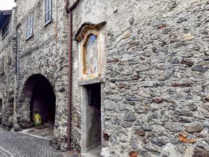an old stone building with a door and a window at La Maison Pilly in Sondalo