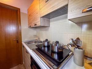a kitchen with pots and pans on a stove at La Maison Pilly in Sondalo +11 photos