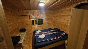 a small room with a bed in a log cabin at Authentic Finnish Lakeside Cottage in Lusila