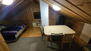 a bedroom with a table and a bed in a room at Authentic Finnish Lakeside Cottage in Lusila +3 photos