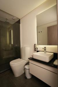 a bathroom with a toilet and a sink and a mirror at Aira Apart Hotel Boutique in Buenos Aires