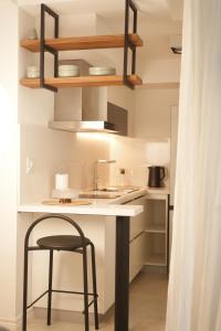 a kitchen with a white counter and a stool at Aira Apart Hotel Boutique in Buenos Aires