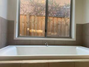 a white bath tub in front of a window at Point Cook Homestay House in Point Cook