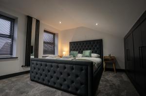 a bedroom with a large bed with a black headboard at Rose House in Boston