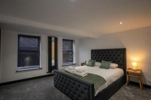 a bedroom with a large bed and two windows at Rose House in Boston