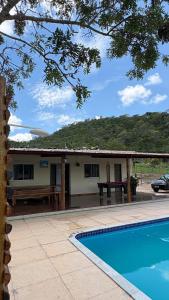 a house with a picnic table and a pool at Refúgio das Araras in Pirenópolis