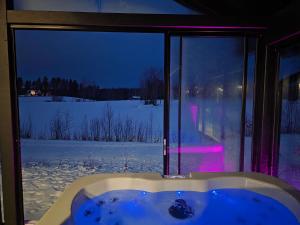 a bath tub in front of a window with snow outside at Villa Taipale - 10hlö, Himosranta in Jämsä