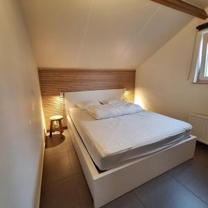 a bedroom with a white bed in a room at Maison Maritime in Middelkerke