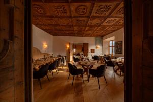 a dining room with tables and chairs and a ceiling at Castel Badia - The Leading Hotels of the World in San Lorenzo di Sebato