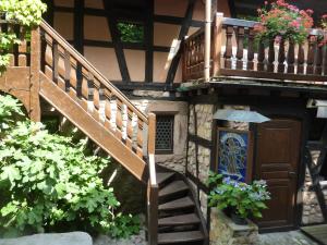 a house with a staircase and a balcony with flowers at Chez Norbert in Bergheim