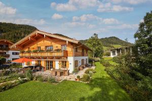 a wooden house with a balcony in a yard at Landhauswohnung Dosbach in Reit im Winkl