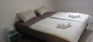 a bed with two towels on top of it at LevelUP in Đakovo