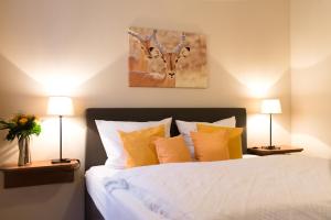 a bedroom with a bed with two lamps and a painting at Boardinghouse Pfarrkirchen in Pfarrkirchen