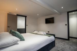 a bedroom with a large white bed and a flat screen tv at Rose House in Boston