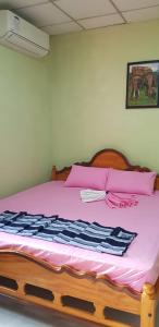 a bedroom with a bed with a pink and black blanket at Vista villa in Panama