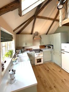 a kitchen with white cabinets and a white counter top at Orchard Barn next to Bewl Reservoir, Ticehurst in Ticehurst