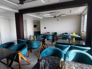 a dining room with blue chairs and tables at Dual Lake in Bhīm Tāl