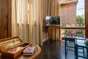 a living room with a table and a television at EDDA - Regarda Travel in Lazise +33 photos