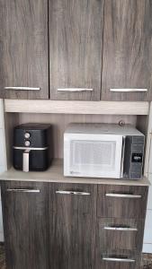 a microwave and a toaster oven on a cabinet at Casa do Sol II in Peruíbe