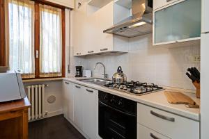 a kitchen with a stove and a sink at EDDA - Regarda Travel in Lazise