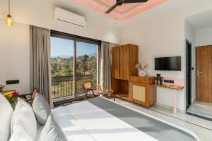 a living room with a large window and a television at Shivaangan By Soma Estates in Udaipur +36 photos