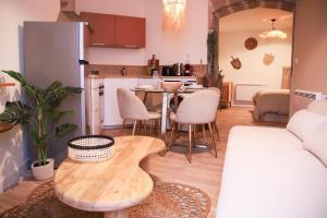 a living room with a table and a kitchen at La Parenthèse Yssoirienne - Balnéo - Vidéoprojecteur in Issoire