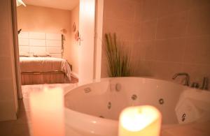 a bathroom with a bath tub with a candle at La Parenthèse Yssoirienne - Balnéo - Vidéoprojecteur in Issoire