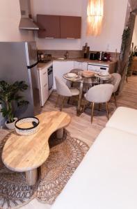 a living room with a table and a kitchen at La Parenthèse Yssoirienne - Balnéo - Vidéoprojecteur in Issoire +19 photos
