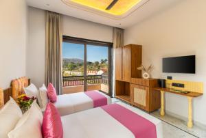 a hotel room with a bed and a tv at Shivaangan By Soma Estates in Udaipur