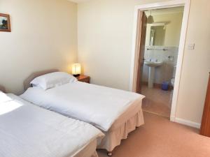 a bedroom with two beds and a bathroom with a sink at Fascadale in Faskadale