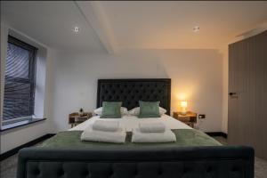 a bedroom with a large bed with green sheets and pillows at Rose House in Boston