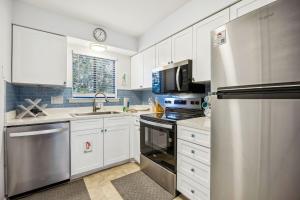 a kitchen with white cabinets and a stainless steel refrigerator at 4F Amelia Landings in Fernandina Beach
