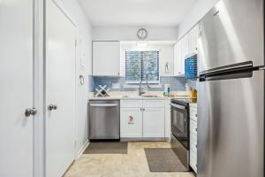 a kitchen with white cabinets and a stainless steel refrigerator at 4F Amelia Landings in Fernandina Beach