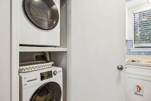 a white laundry room with a washer and dryer at 4F Amelia Landings in Fernandina Beach