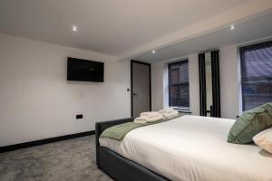 a bedroom with a large bed with a tv on the wall at Rose House in Boston +23 photos