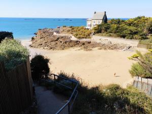 a sandy beach with a house and the ocean at Plage du Pont - Chambres d'Hôtes in Saint Malo +6 photos