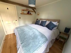 a bedroom with a bed with a blue blanket on it at Orchard Barn next to Bewl Reservoir, Ticehurst in Ticehurst
