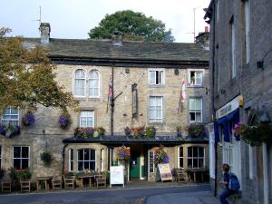 an old building with tables and chairs in front of it at Chamber End Fold in Skipton