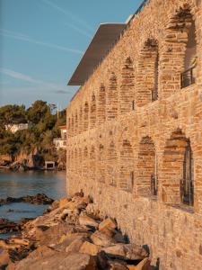 an old brick building next to the water at Hôtel Les Roches - Relais & Châteaux in Le Lavandou +25 photos