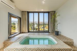 a swimming pool in a room with a large window at Shivaangan By Soma Estates in Udaipur