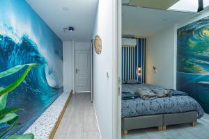 a bedroom with a large painting on the wall at Capsule Océan 2 Chambres- Billard - Jacuzzi - Netflix in Valenciennes +37 photos