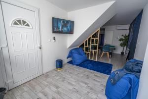 a living room with two blue chairs and a staircase at Capsule Océan 2 Chambres- Billard - Jacuzzi - Netflix in Valenciennes